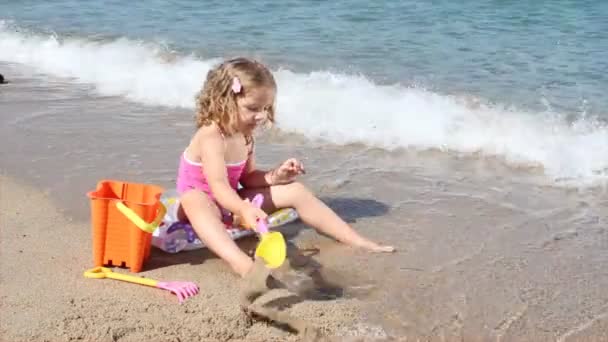 Liten flicka som leker på stranden — Stockvideo