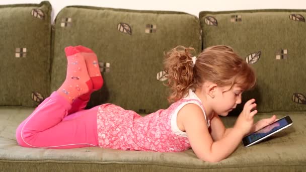 Девочка играет с планшетным компьютером — стоковое видео