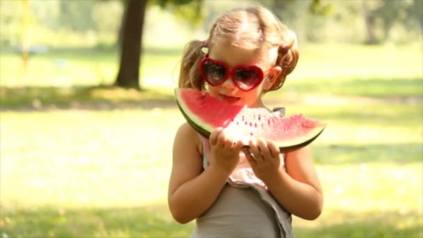 Little girl with sunglasses eat watermelon — Stock Video