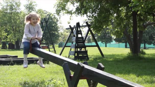 Young girl fun on seesaw — Stock Video