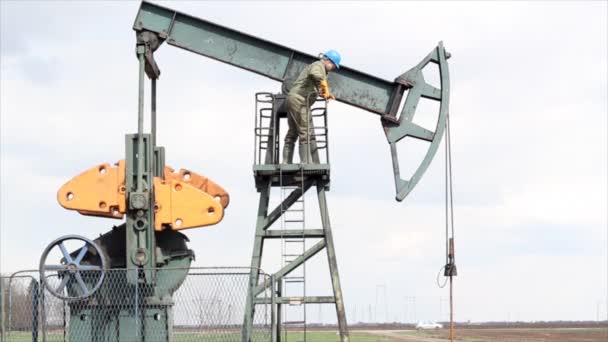 Trabalhador do petróleo em pé no macaco da bomba — Vídeo de Stock