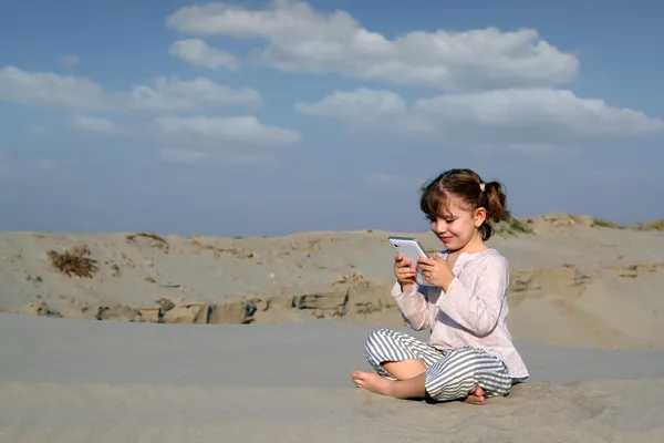 Little girl play with tablet pc in desert — Stock Photo, Image