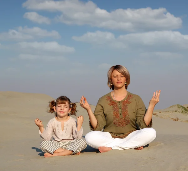 Mãe e filha meditando no deserto — Fotografia de Stock