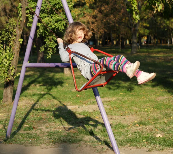 Gelukkig klein meisje op swing — Stockfoto
