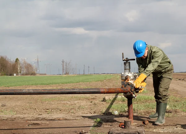 Oil worker closes the valve — Stock Photo, Image