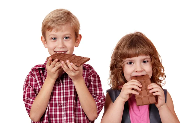 Pojken och flickan äta choklad — Stockfoto