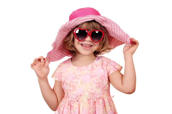 Glückliches kleines Mädchen mit großem Hut und Sonnenbrille auf weißem Grund — Stockfoto