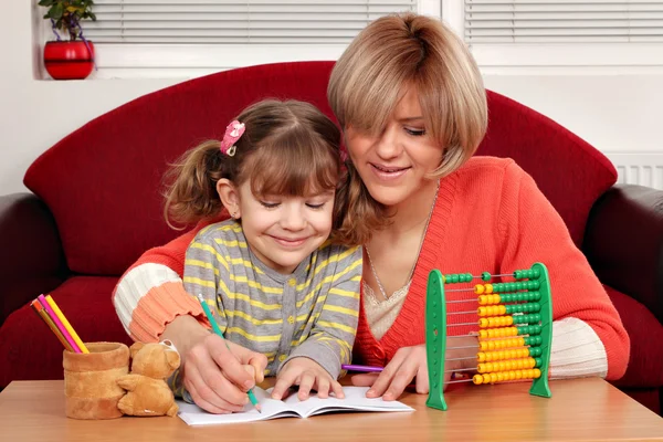 Mother and daughter doing homework family scene — Stock Photo, Image