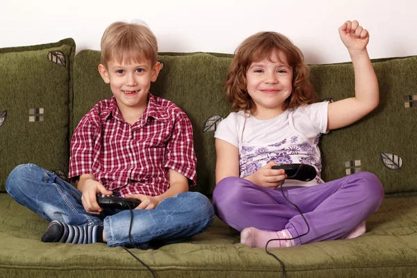 Маленькая девочка и мальчик играют в видеоигры — стоковое фото