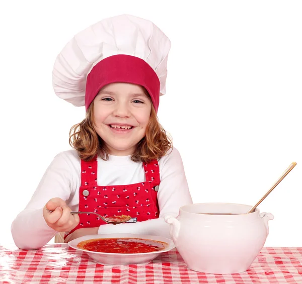 Happy little girl cook eating soup — Stock Photo, Image