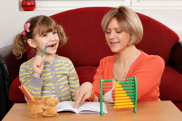 Moeder helpt dochter om te lossen huiswerk — Stockfoto