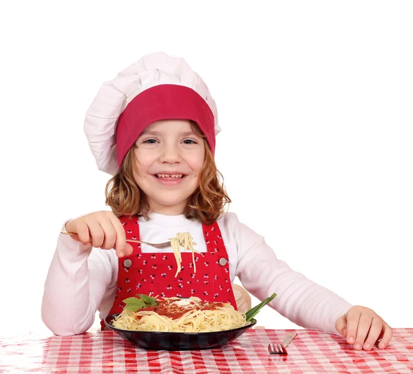 Menina feliz cozinheiro comer espaguete — Fotografia de Stock