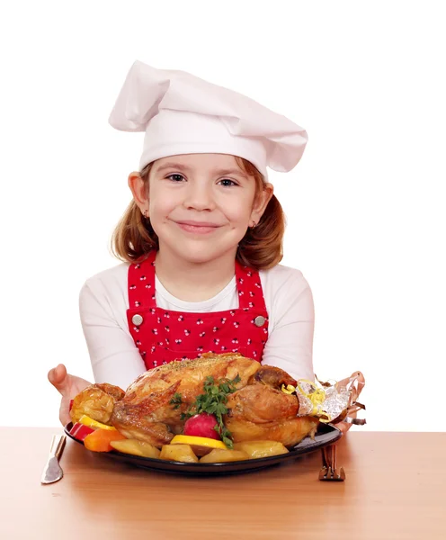 Belle petite fille cuisinier avec poulet rôti sur la table — Photo