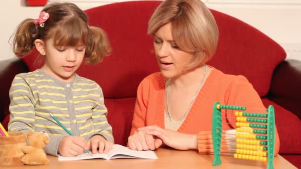 Маленька дівчинка працює над домашнім завданням і робить помилку — стокове відео