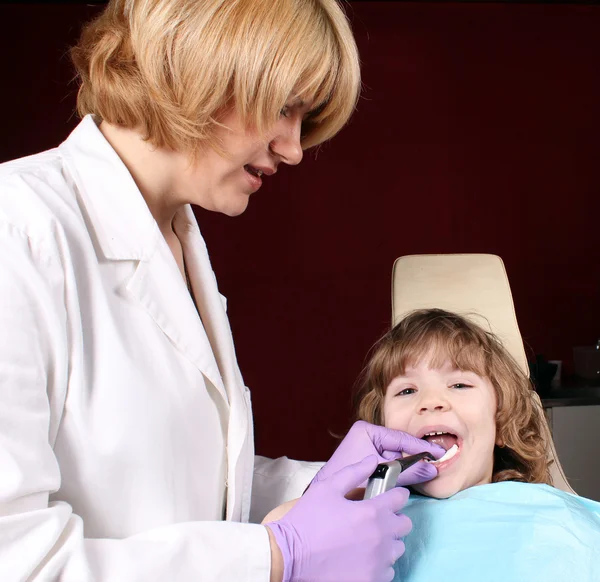 Mujer dentista y niña pequeña paciente — Foto de Stock