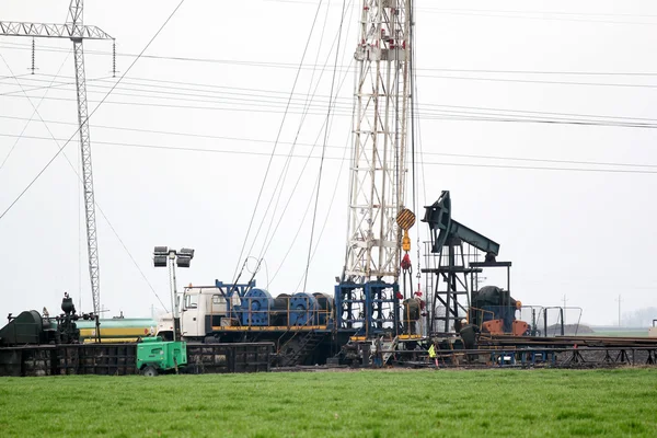 Zware industrie olieveld met tuig en pomp jack — Stockfoto