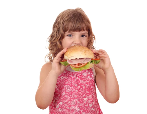 Hungrige kleine Mädchen essen große Sandwich auf weiß — Stockfoto