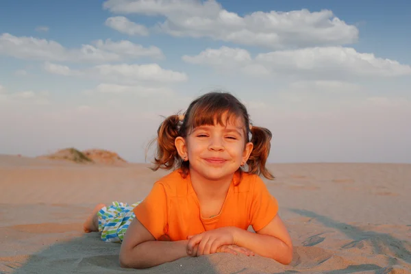 Niña feliz acostada en la playa — Foto de Stock