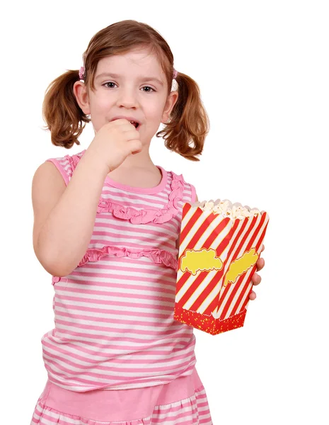 Liten flicka äter popcorn på vit — Stockfoto