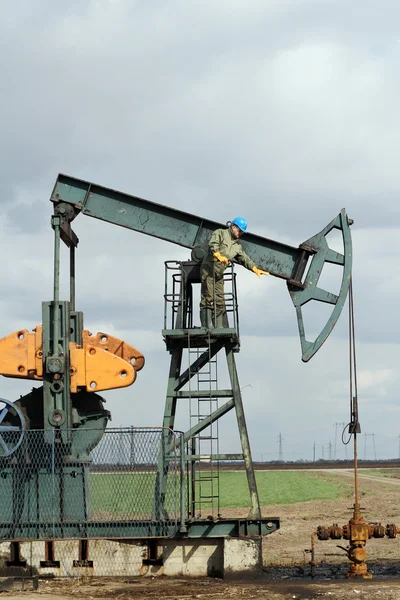 Ölfeld mit Arbeiter und Pumpenheber — Stockfoto