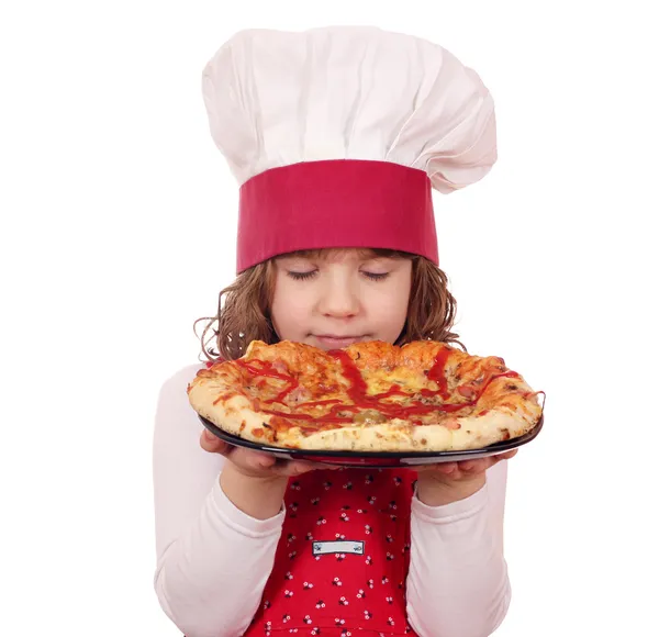 Menina cozinheiro cheira pizza — Fotografia de Stock