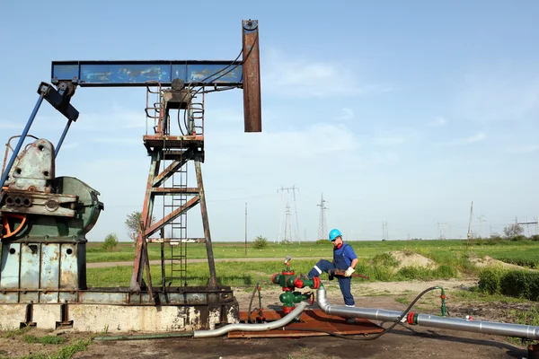 Oil worker with wrench on oil field — Stock Photo, Image