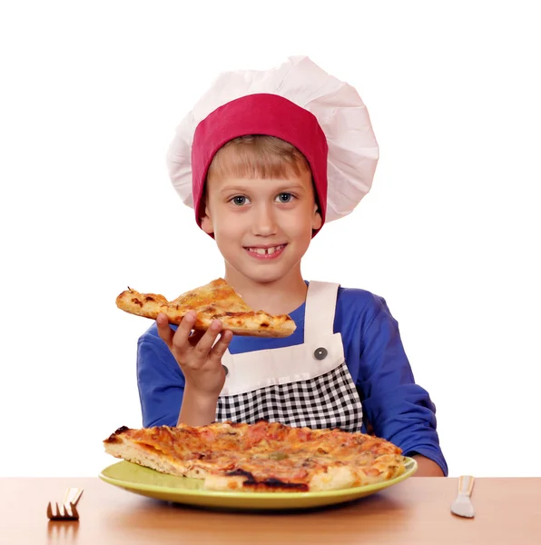 Голодный мальчик-повар ест пиццу на белом — стоковое фото