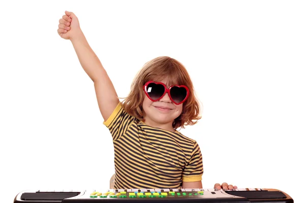 Счастливый ребенок играет музыку на клавиатуре — стоковое фото
