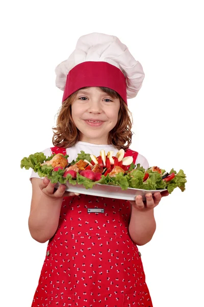 Šťastná holčička vařit s plněné kuřecím masem a salátem — Stock fotografie