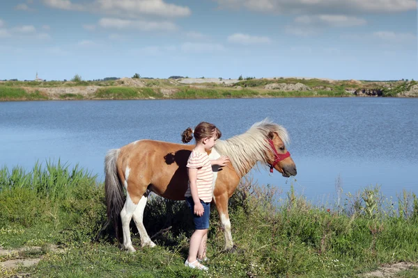 Belle petite fille avec cheval de poney — Photo