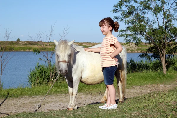 Щаслива маленька дівчинка з поні конем — стокове фото