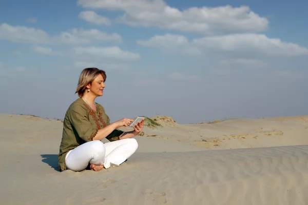 Mooie vrouw met tablet pc in de woestijn — Stockfoto