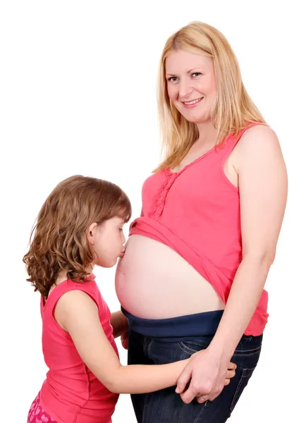 Little girl kissing belly of pregnant woman — Stock Photo, Image