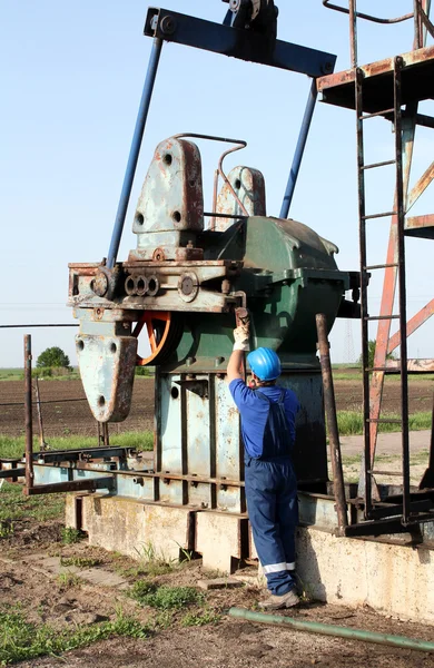 Operaio petrolifero con chiave a tubo funzionante — Foto Stock