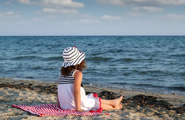 Little girl sitting on beach — Stock Photo, Image