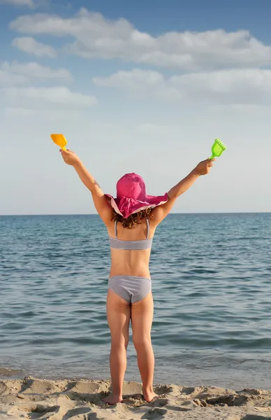 Gelukkig weinig met handen omhoog op strand zomer scène — Stockfoto