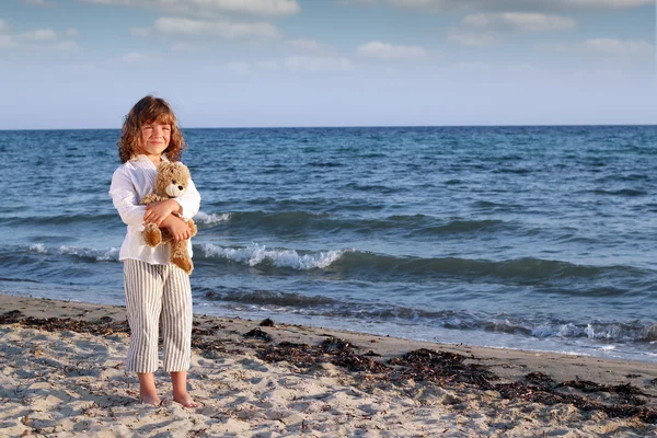 Vacker liten flicka med Nalle på stranden — Stockfoto