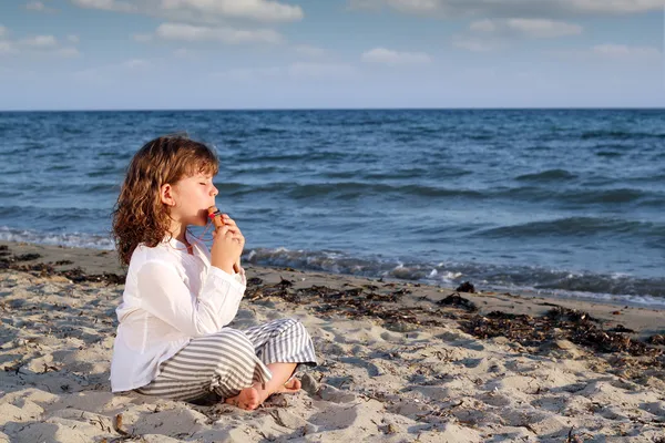 Little girl play pan pipe on beach — Stock Photo, Image