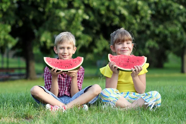 Little girl and boy eat watermelon — Zdjęcie stockowe