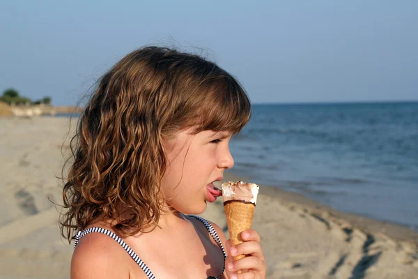 小さな女の子はビーチの肖像にアイスクリームを食べる — ストック写真
