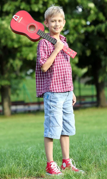 Garçon heureux avec guitare dans le parc — Photo