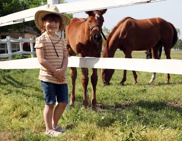 Glückliches kleines Mädchen und Fohlen auf dem Bauernhof — Stockfoto