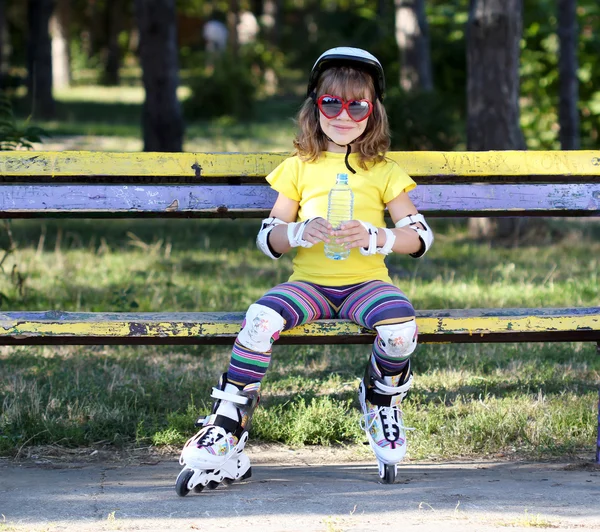 Little girl with roller skates and water — Stock Photo, Image