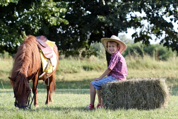 Heureux garçon et cheval de poney à la ferme — Photo