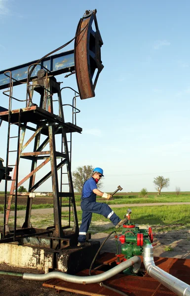 Oil worker with hammer on oilfield — Stock Photo, Image