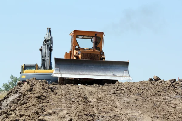 Heavy bulldozer and excavator on road construction — Stock Photo, Image
