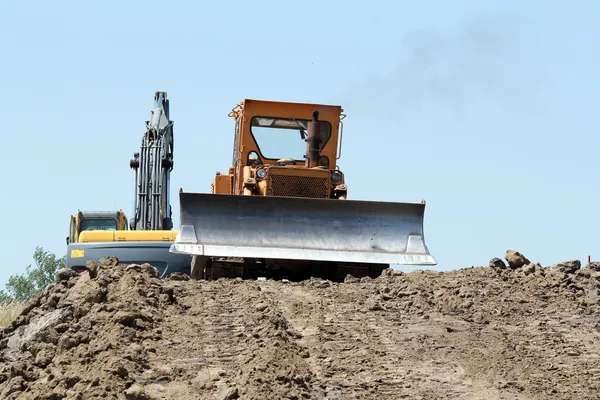 Schwere Planierraupe und Bagger im Straßenbau — Stockfoto