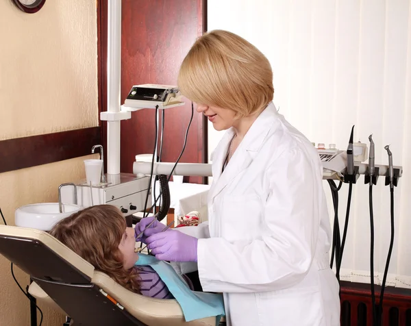Dentista feminina e paciente menina no consultório odontológico — Fotografia de Stock