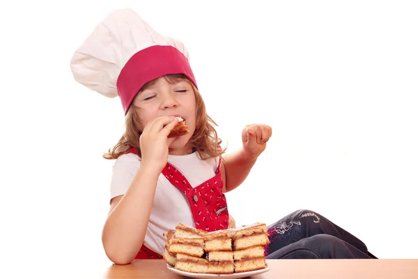 Hungry little girl cook eat apple cake — Stock Photo, Image