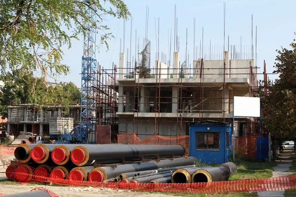 Canteiro de obras com tubos e guindaste — Fotografia de Stock